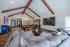 Inviting community room with vaulted wood beam ceiling, cozy seating, large TV, and modern art, perfect for relaxation or social gatherings.