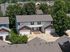 Charming duplex with a double garage nestled in a serene neighborhood surrounded by lush greenery.