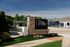 Inviting entrance at The Row featuring elegant stone signage and lush greenery, highlighting a vibrant community setting.