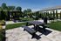 Charming outdoor recreational area with picnic tables, grills, lush greenery, and cozy seating, perfect for gatherings.