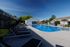 Inviting outdoor pool area with modern lounge chairs and a serene setting, perfect for relaxation and social gatherings.