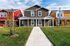 Charming suburban homes with vibrant exteriors, set against a clear blue sky and a well-maintained front lawn.