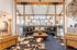 Elegant and spacious open-concept living room with modern decor, featuring a stylish leather sectional, rustic wooden accents, and abundant natural light.