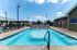 Inviting outdoor pool area surrounded by comfortable loungers and shaded seating, perfect for relaxation and enjoyment.