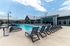Inviting outdoor pool area with modern lounge chairs and stylish architecture under a clear blue sky.