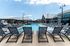 Luxurious outdoor pool area with stylish lounge chairs and shaded seating, perfect for relaxation and leisure.