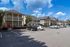 Charming townhouse community with modern two-story buildings, ample parking, and vibrant landscaping under a bright blue sky.