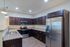 Modern kitchen featuring sleek stainless steel appliances, dark wood cabinetry, and elegant granite countertops.
