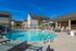 Inviting outdoor pool area with modern lounge chairs under a clear blue sky, ideal for relaxation and leisure.