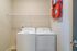 Modern laundry nook with a sleek washer and dryer, complemented by convenient wall shelving for smart storage solutions.