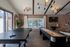 Inviting recreation room with modern lighting, featuring a sleek ping pong table and shuffleboard table next to large windows offering natural light.