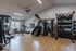 Modern fitness center with state-of-the-art equipment, including treadmills, weight machines, and stability balls, set in a bright, spacious room with stylish flooring.