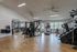 Modern fitness center with state-of-the-art gym equipment, large windows, and sleek wooden flooring.