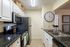 Modern kitchen with sleek stainless steel appliances, elegant white cabinetry, and stylish black countertops for a chic and functional cooking space.