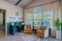 Charming living space at The Vine, featuring elegant armchairs, lush indoor plants, and abundant natural light through large windows.