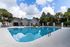 Inviting outdoor pool area with plush lounge chairs and lush palm trees, offering a serene oasis for relaxation and leisure.