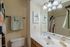 Elegant bathroom with stylish lighting, a sleek vanity, and modern decor, featuring lush greenery and soft, soothing colors.