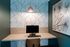 Modern home office nook with stylish geometric wallpaper, sleek wooden desk, and minimalist decor, ideal for productivity.