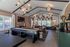 Chic entertainment room with vaulted ceiling, shuffleboard table, and cozy seating area, ideal for relaxation and social gatherings.