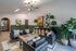 Chic and modern lounge area with sleek black armchairs, lush green plants, and artistic decor, offering a welcoming and stylish atmosphere.