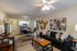 Inviting open-plan living room featuring a modern black sofa, stylish art pieces, and a cozy dining area with natural lighting.