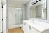 Luxurious bathroom with marble accents, sleek glass shower, and modern vanity with ample counter space.