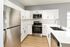 Modern kitchen with sleek stainless steel appliances, elegant white cabinetry, and luxurious marble countertops.