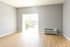 Bright and spacious room with elegant wooden flooring, large windows, and abundant natural light creating a welcoming atmosphere.