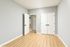 Bright bedroom with elegant double doors, chic neutral walls, and stunning natural wood flooring.