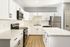 Modern kitchen with sleek white cabinetry, stainless steel appliances, and a spacious marble island, exuding elegance and functionality.
