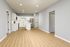 Contemporary open-plan kitchen with sleek white cabinetry, stainless steel appliances, and luxurious hardwood floors.