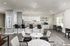 Bright and modern communal kitchen with granite countertops, sleek bar stools, and elegant decor, perfect for social gatherings.