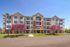 Elegant apartment complex surrounded by vibrant blooming trees and beautifully maintained landscaping, featuring modern architectural design and welcoming balconies.
