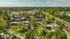 Charming aerial view of a leafy residential community with brick apartment buildings, nestled among lush greenery and scenic surroundings.