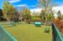 Charming pet-friendly park with lush green lawn, cozy bench seating, and vibrant trees, perfect for relaxation and play.