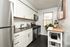 Chic modern kitchen with stainless steel appliances, white cabinetry, and a stylish granite countertop, perfect for culinary adventures.