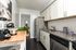 Chic kitchen featuring modern stainless steel appliances, elegant granite countertops, and stylish white cabinetry.
