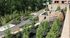 Beautiful landscaped garden with stone paths, lush greenery, and rustic stone structures offering a serene outdoor space.
