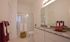 Elegant bathroom featuring a granite countertop, modern fixtures, and a sleek glass shower enclosure.