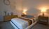 Elegant bedroom with chic decor, featuring a modern striped bedspread, stylish wooden nightstands, and ambient lighting creating a cozy atmosphere.