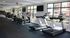 Bright, modern gym with natural light, equipped with treadmills, elliptical machines, and a variety of fitness equipment.