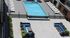 Luxurious outdoor pool area with sparkling water, surrounded by sleek lounge chairs and vibrant flower arrangements, perfect for relaxation and entertainment.