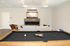 Inviting recreation room with a stylish billiards table, modern fireplace, and a cozy seating area, perfect for entertainment and relaxation.