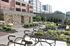 Modern apartment building with landscaped gardens, featuring bike racks and seating areas for relaxation.