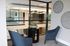 Elegant apartment lounge area featuring modern chairs, a trendy side table with a succulent centerpiece, and decorative wall art, overlooking a chic interior with stylish lighting.