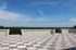 Expansive rooftop terrace featuring stunning views, elegant checkered decking, and a serene blue sky backdrop.