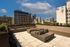 Chic urban rooftop patio with plush seating, modern fire feature, and stunning city skyline backdrop.