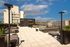 Stunning rooftop terrace with modern seating and panoramic city views, perfect for relaxing and socializing in a vibrant urban setting.