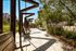 Charming outdoor space with modern benches, lush greenery, and a serene city backdrop.