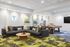Inviting recreational room featuring a plush sofa, vibrant green-patterned carpet, and a classy pool table for entertainment.